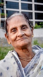 An older woman smiles at the camera.