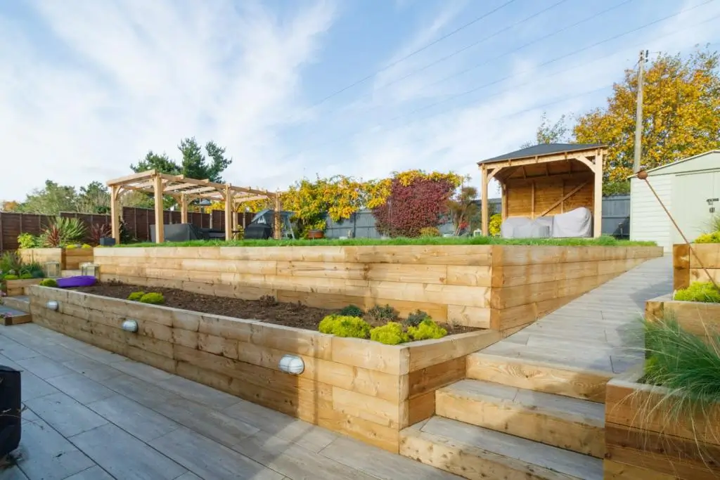 Modern building with a landscaped garden, brick pathways, and a clear blue sky in the background.