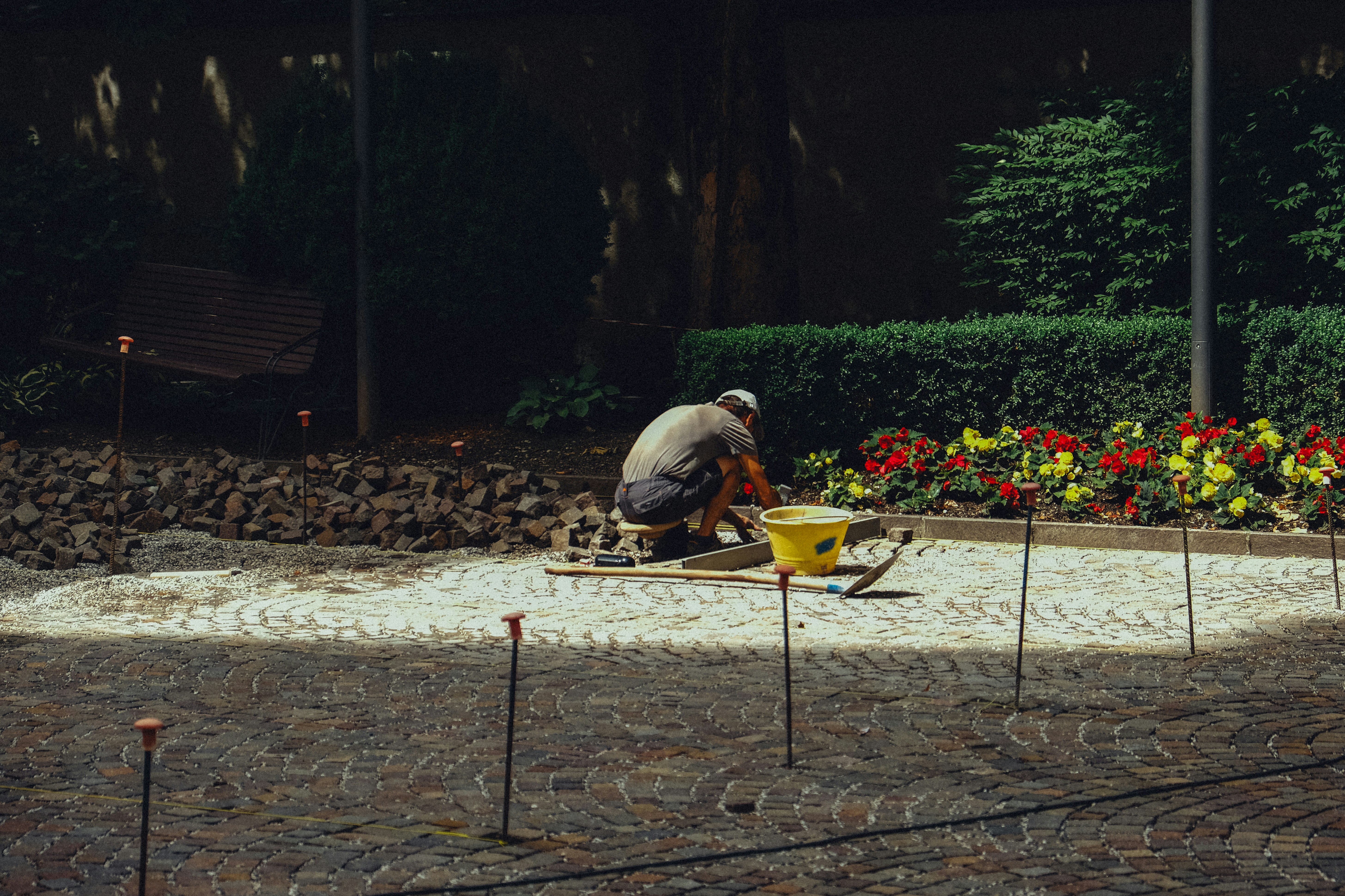 Gardener laying stones in a flower bed