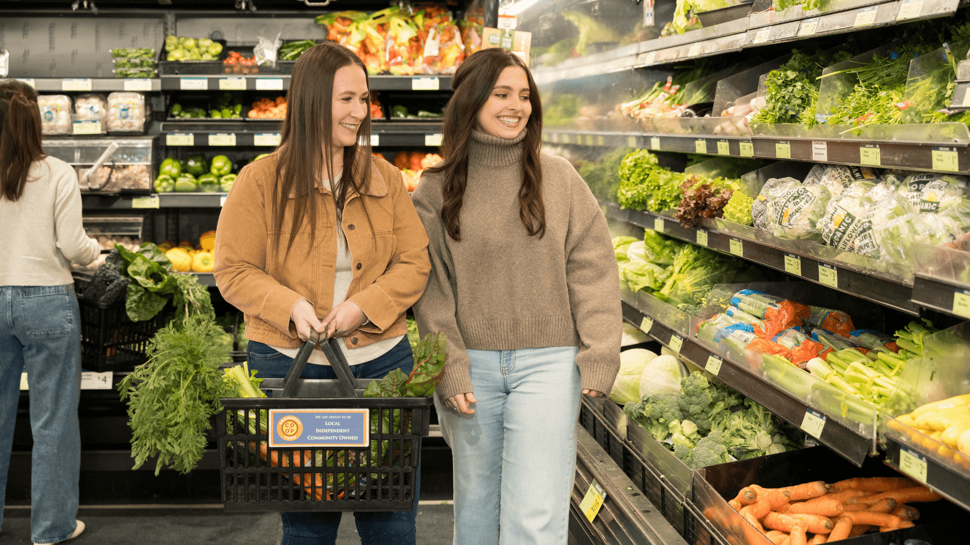 Interior of a grocery store with wooden displays of various fruits and vegetables arranged neatly.