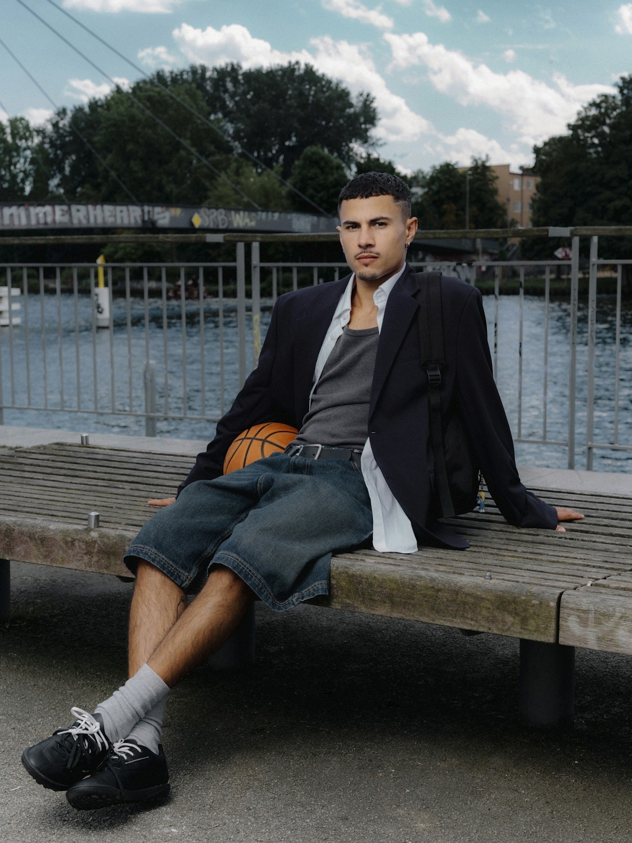 Guy sitting on the bench along with a basketball