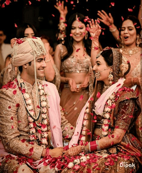 Elegant Indian wedding ceremony showcasing the bride and groom under a decorated mandap with floral garlands and intricate ornamentation, symbolising sacred traditions in wedding photography.