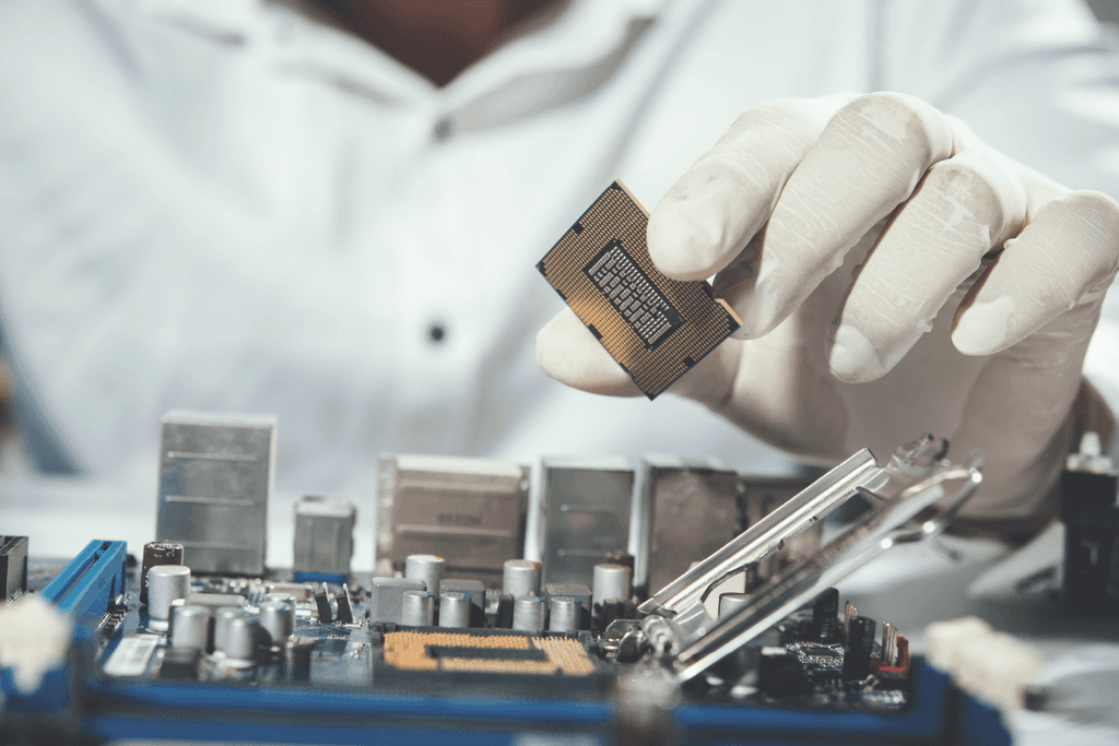 Técnico instalando processador em placa-mãe de computador com luvas de proteção - FindUP