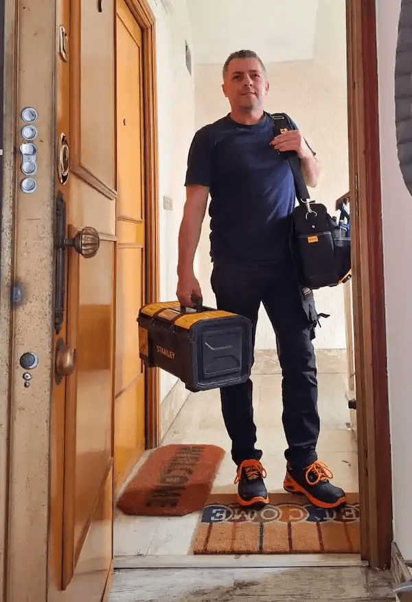 Titolare della S.A.Multiservizi Roma davanti appartamento con strumentazione tecnica e certificati