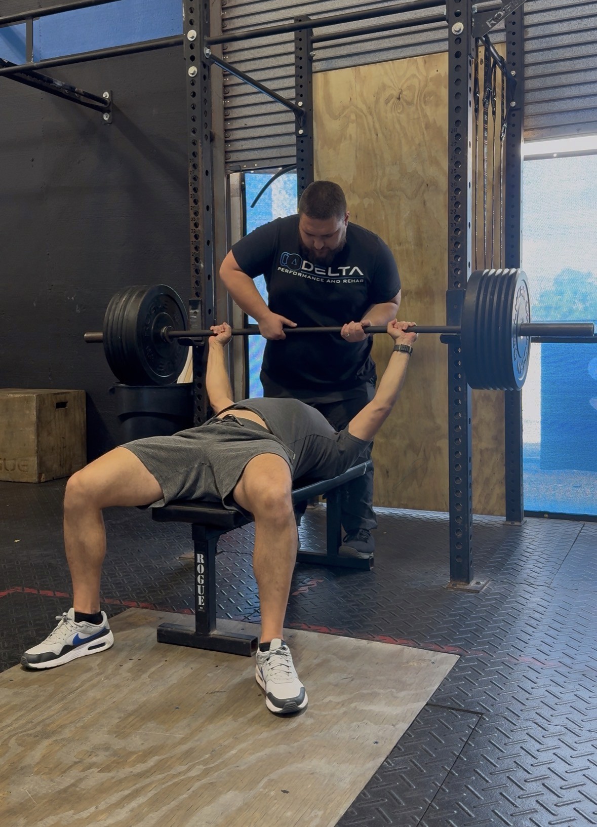 Man performing a deep lunge stretch in a strength training facility, focusing on mobility, joint health, and flexibility—key pillars of performance therapy and rehab.