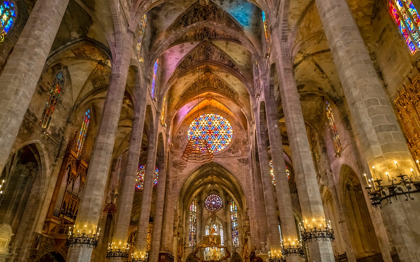 Interior gótico con vitrales y columnas en la Catedral de Palma.
