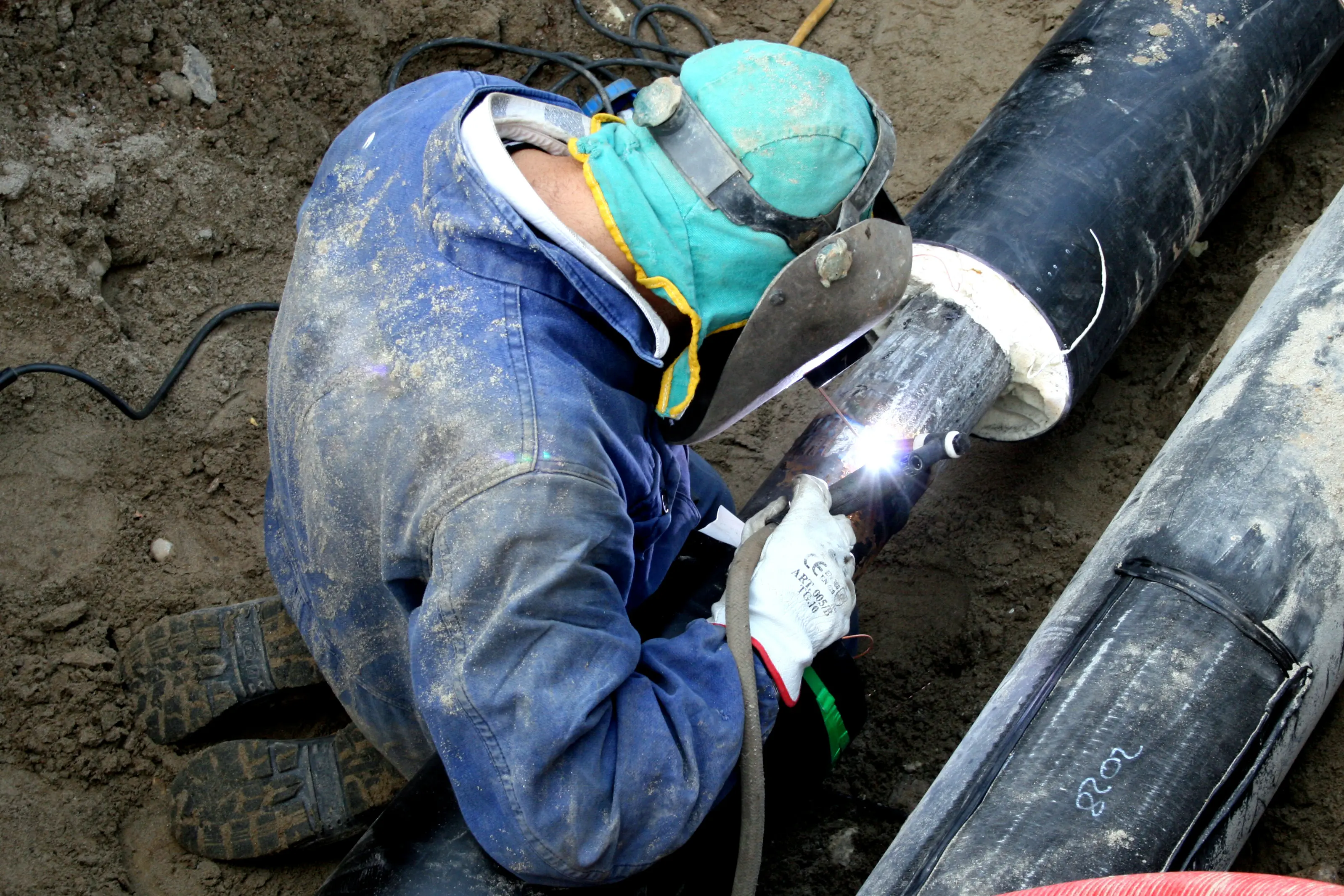Technicien en train de souder du calorifuge sur un chantier de raccordement de chauffage urbain