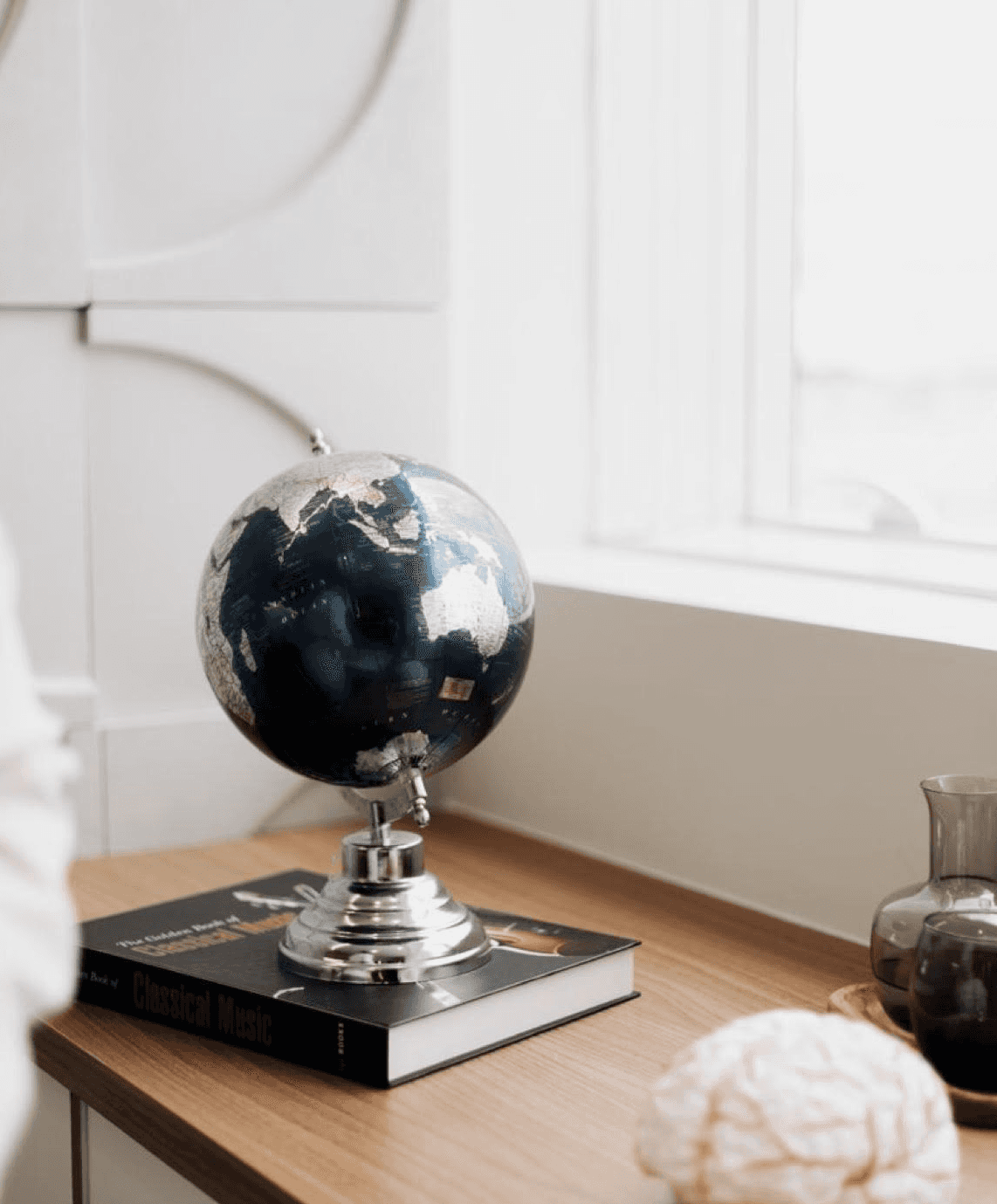 village near cliff and body of water under white clouds