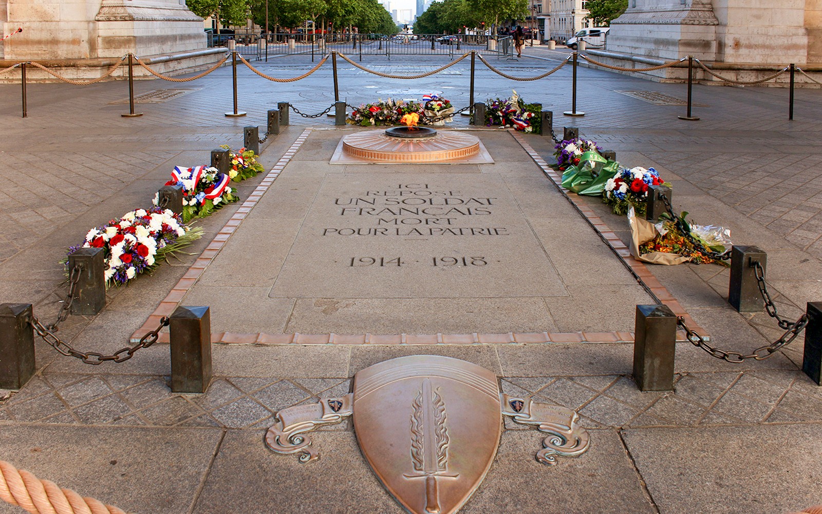 巴黎凯旋门无名战士墓，永恒的火焰燃烧着，四周环绕着鲜花。