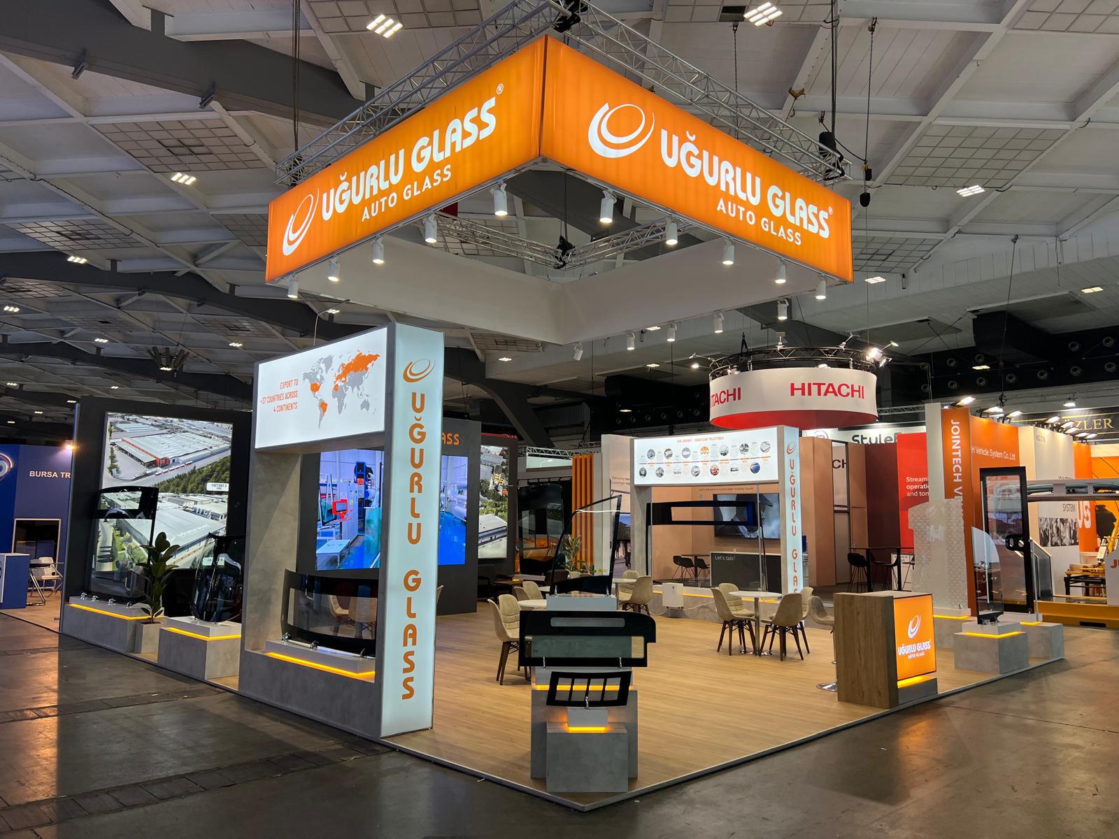 LED screen on the main back wall of the Uğurlu Glass stand, presenting corporate videos and factory visuals.