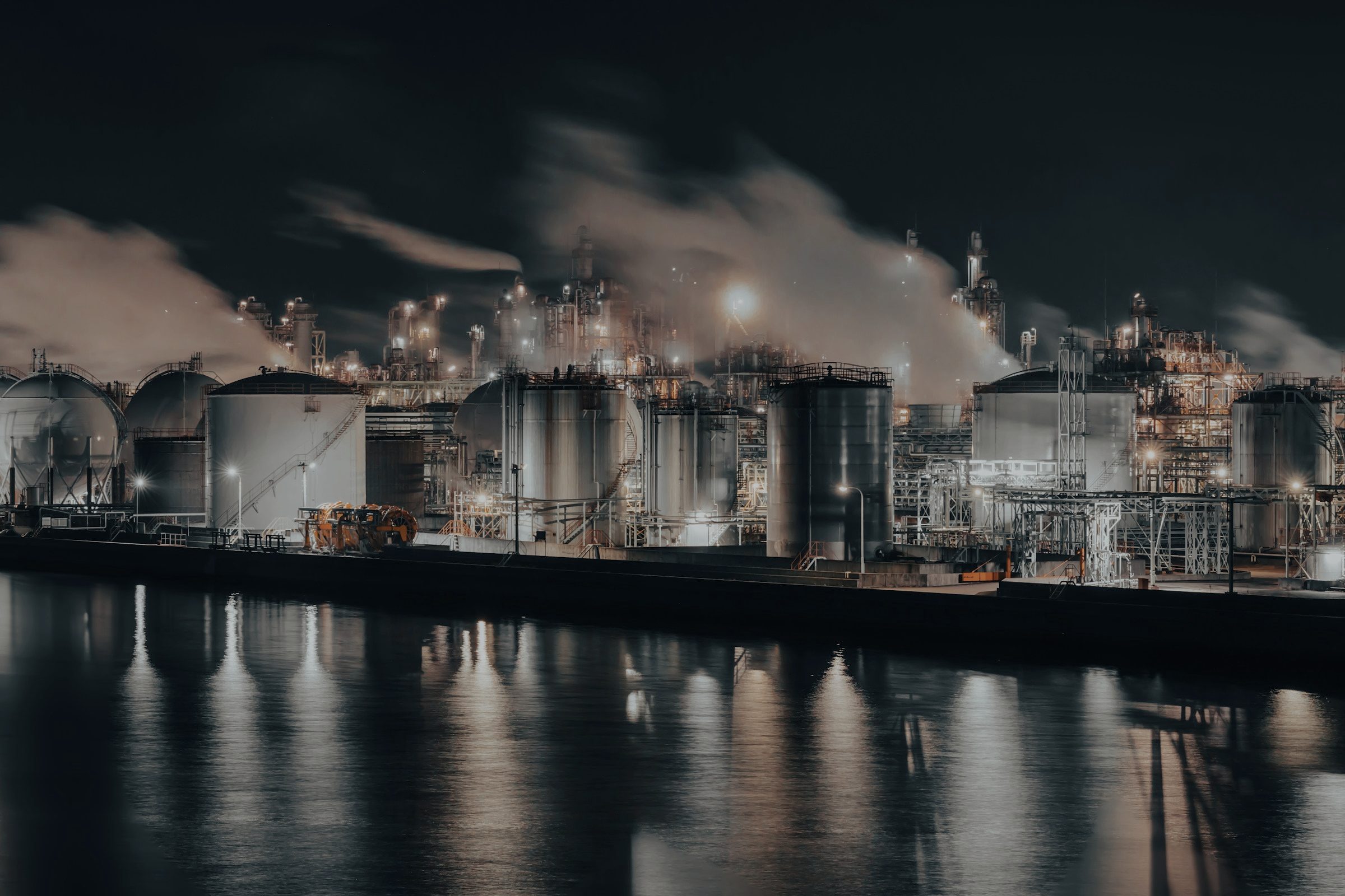 Refinery lit up at night across the water