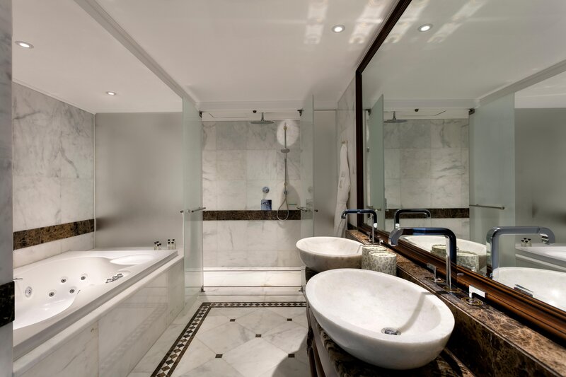 Jacuzzi bathroom with shower, branded amenities, and a refined design.