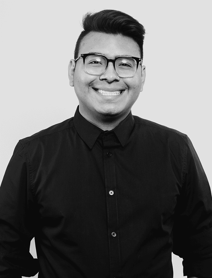 Portrait of a young man with short hair, wearing a dark t-shirt, against a plain background.