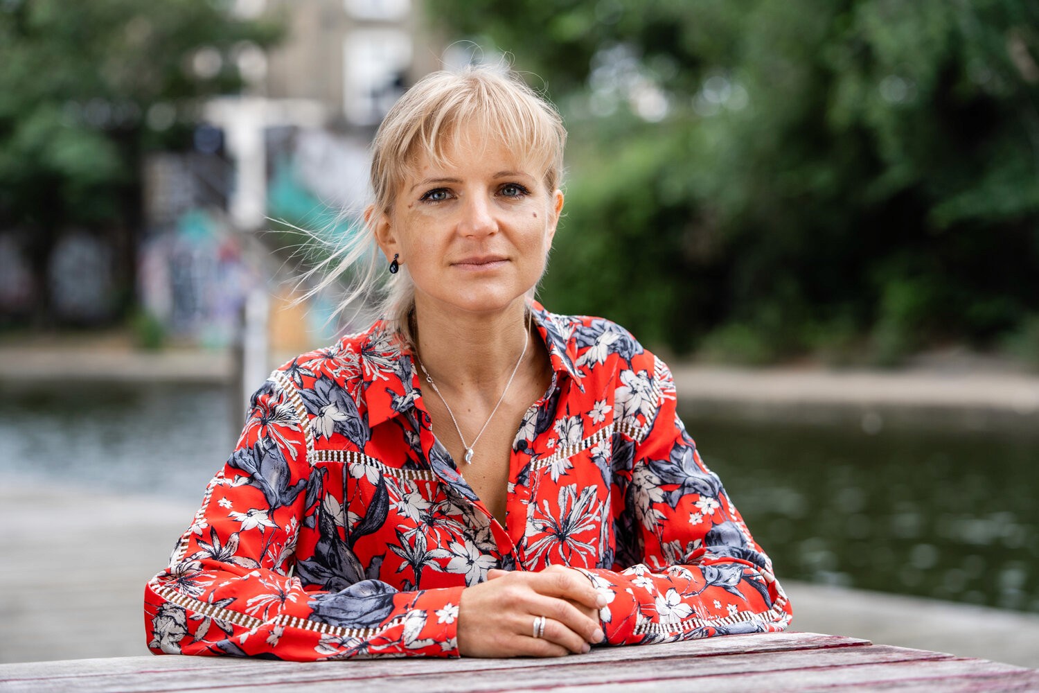 woman in a floral shirt seated outdoors