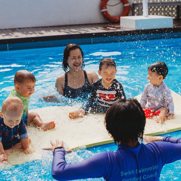 Parent and young child practising water confidence together in a swimming pool