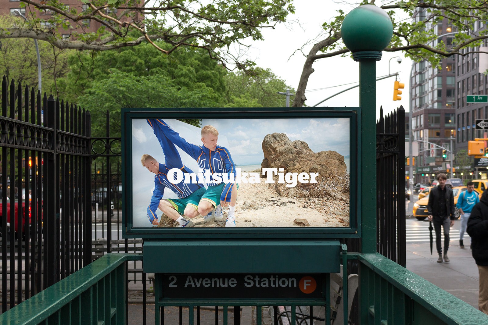 Subway entrance with a digital display featuring an outdoor scene and an Israeli flag in a bustling urban setting.