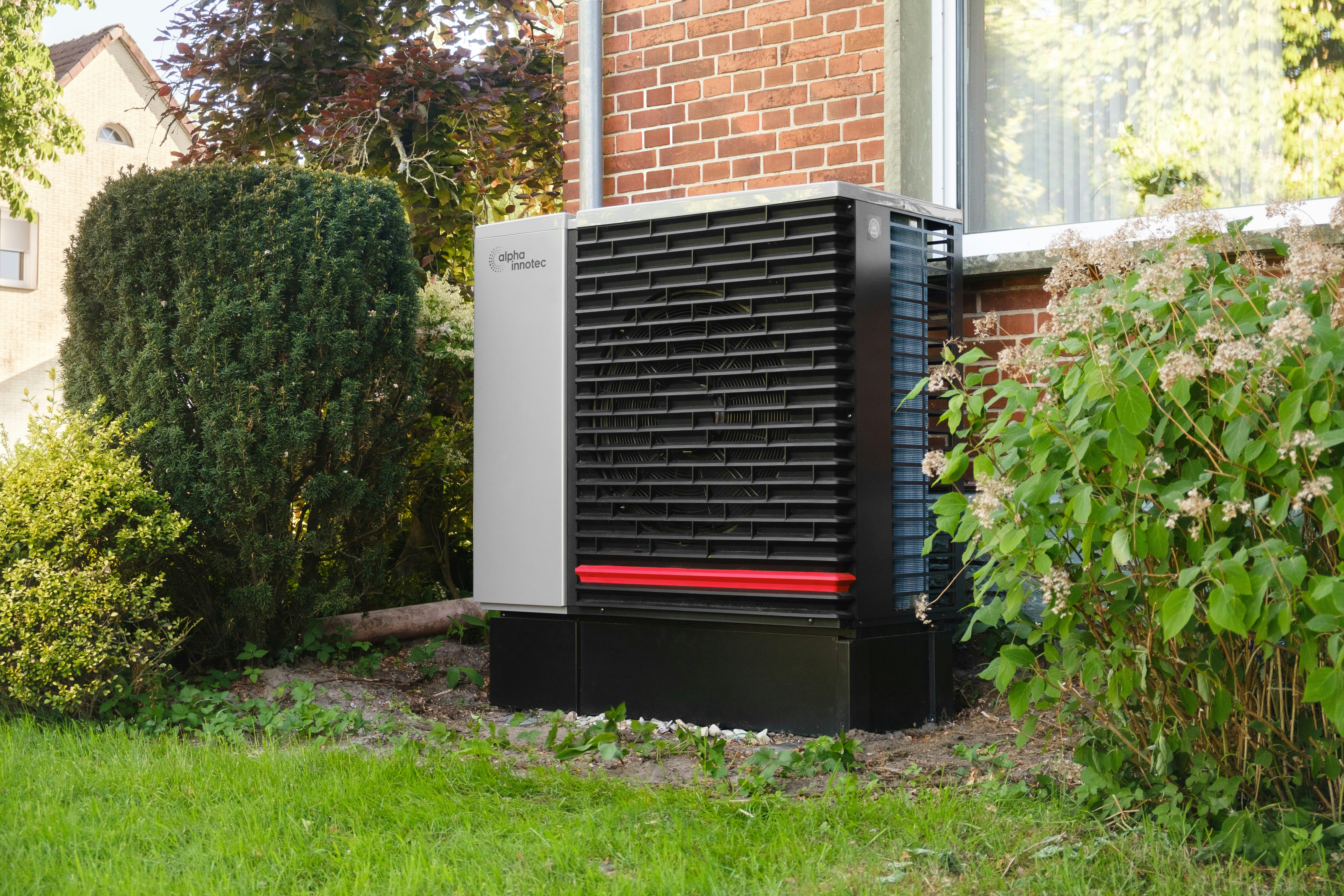 Outdoor heat pump unit next to a brick building.