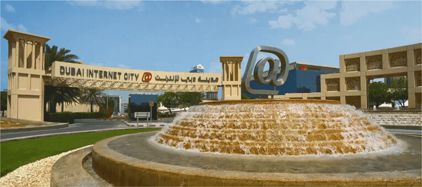 صورة عند المدخل الرئيسي لـمدينة دبي للإنترنت تظهر نافورة عصرية باللون الأصفر.
