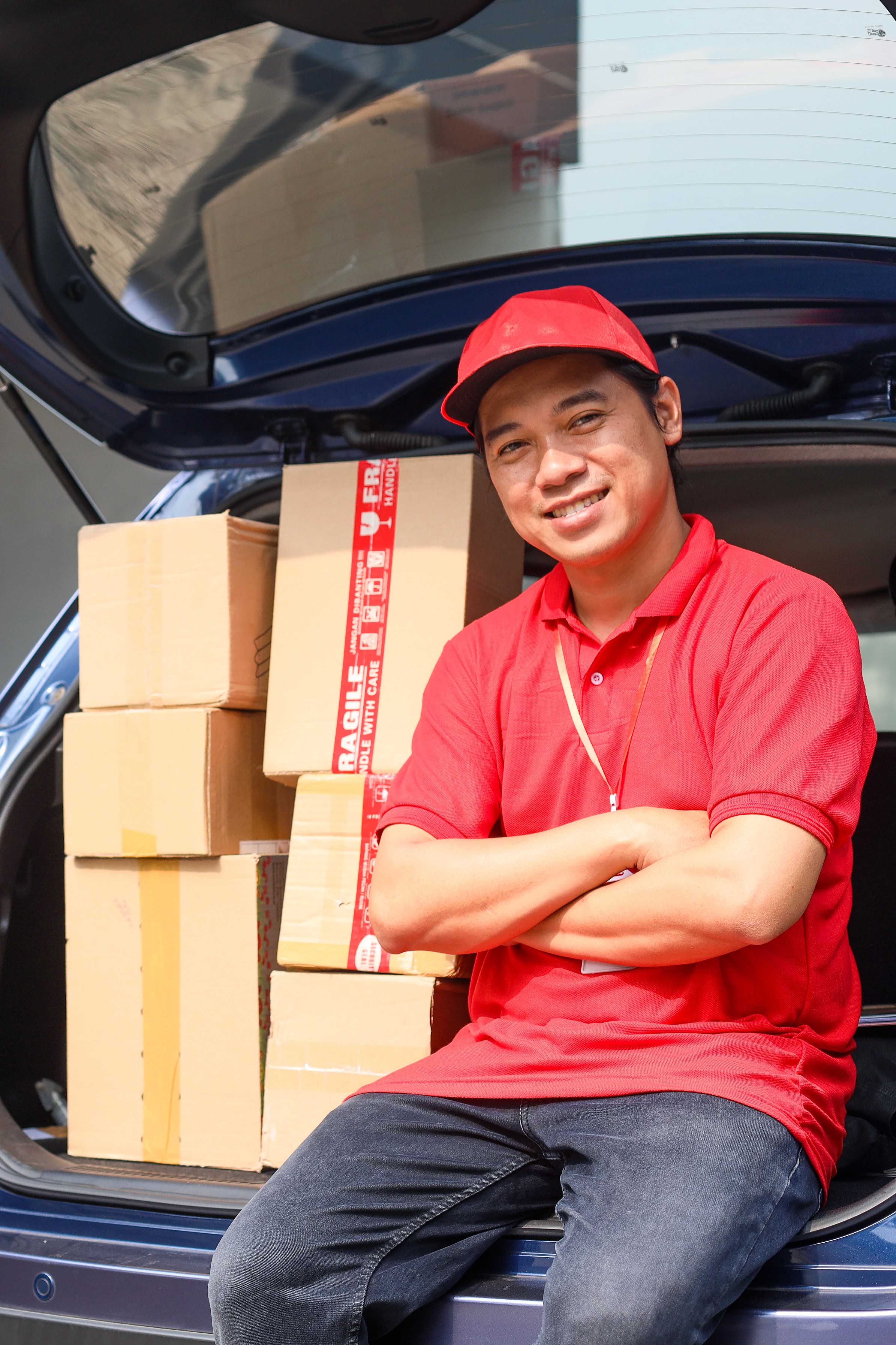 Man sitting in a car next toboxes
