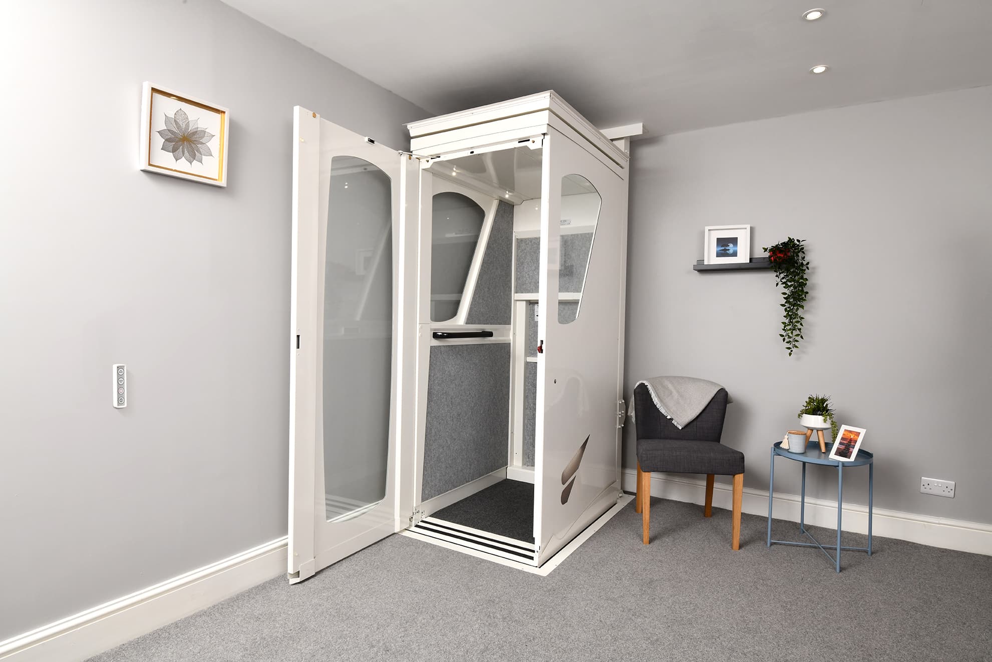 alt text for this image11:57Claude responded: Interior of an Elevate AVA Rise home lift cabin showing fold-down upholstered seat, stainless steel control panel with floor selection buttons, handrail, and g…Interior of an Elevate AVA Rise home lift cabin showing fold-down upholstered seat, stainless steel control panel with floor selection buttons, handrail, and glass door panel — white cabin finish with indoor plant visible alongside