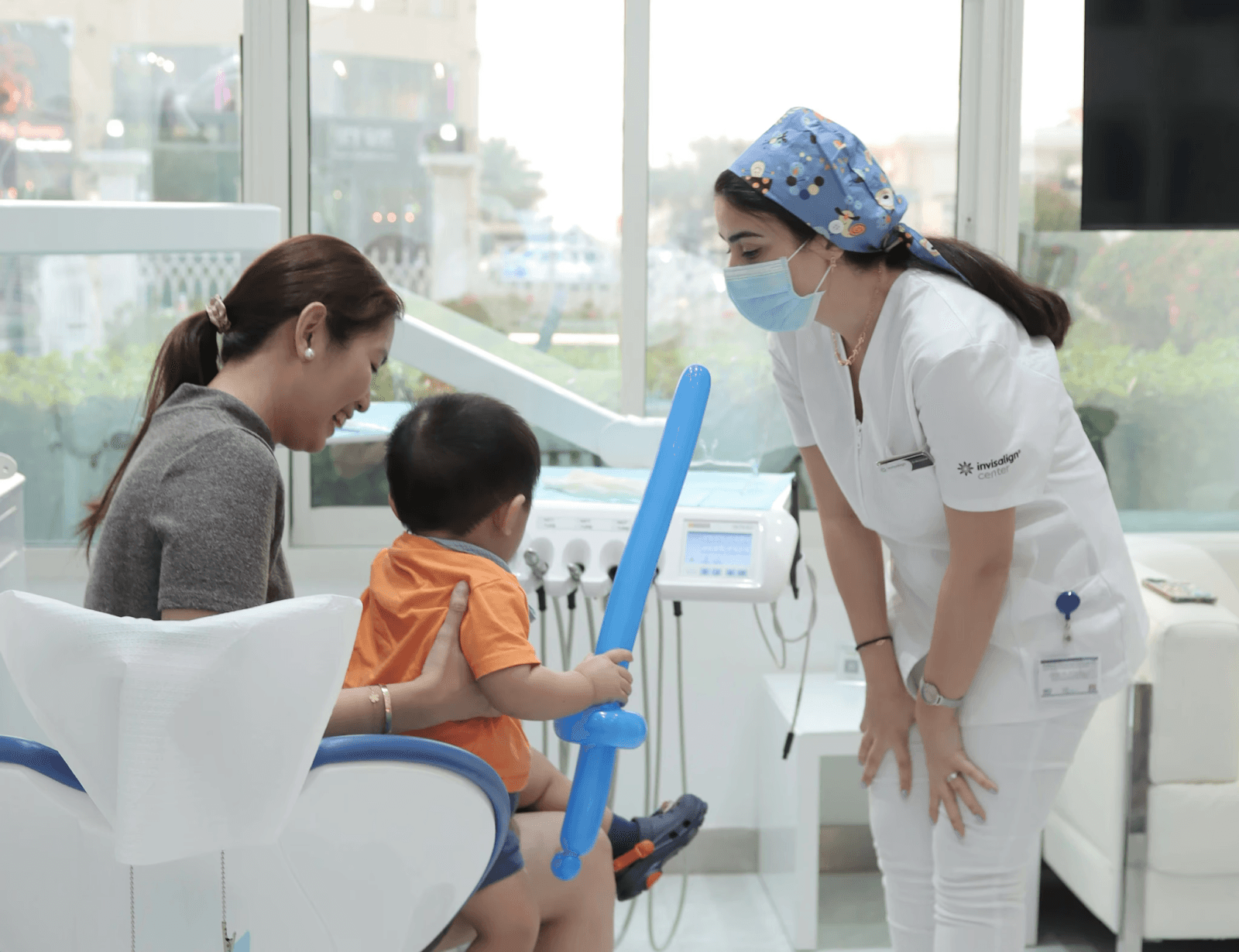 طبيبة أسنان أطفال تخلق بيئة مرحة مع طفل في مركز انفزلاين لكسر حاجز الخوف قبل فحص تسوس الأسنان.