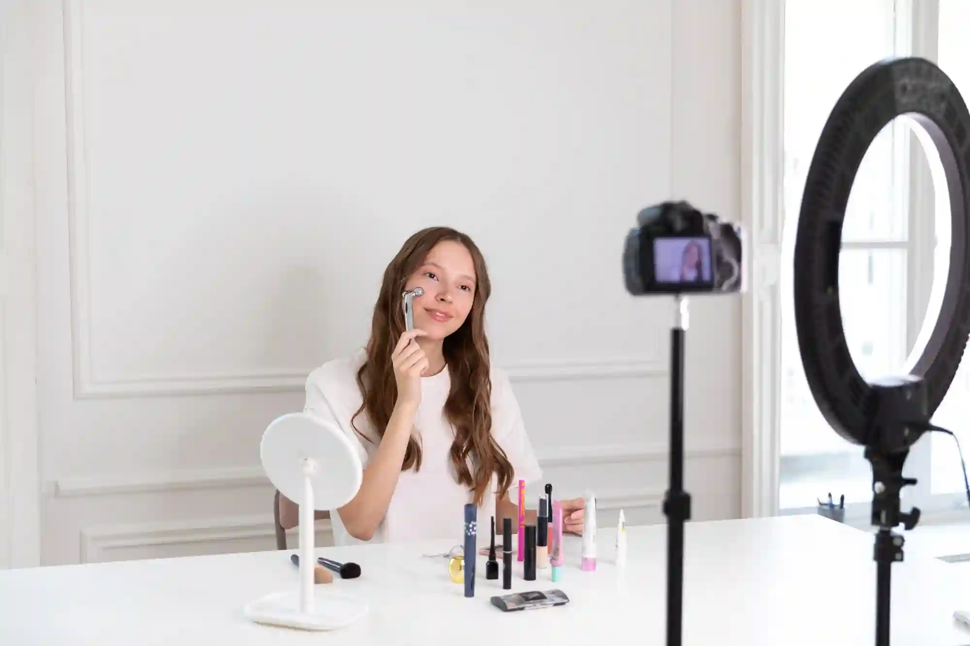 Beauty influencer recording a makeup tutorial video in a brightly lit studio setup for her followers.