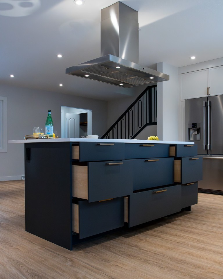 Image of Modern kitchen island with navy blue drawers and white countertop, part of KHD Homes design-build renovations.