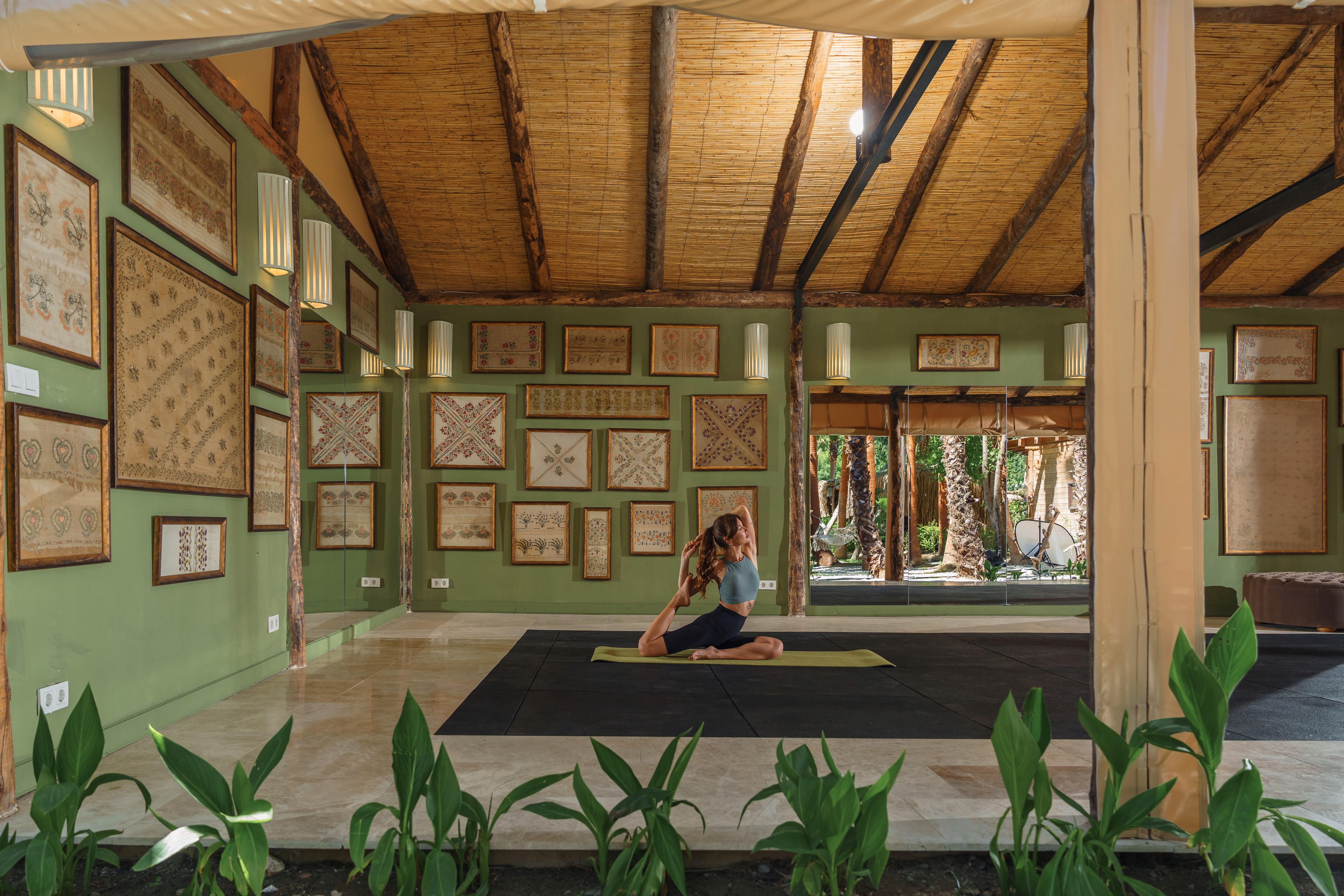 A light-filled fitness space with arched windows inside a coastal Mediterranean-modern villa, facing the ocean. 
