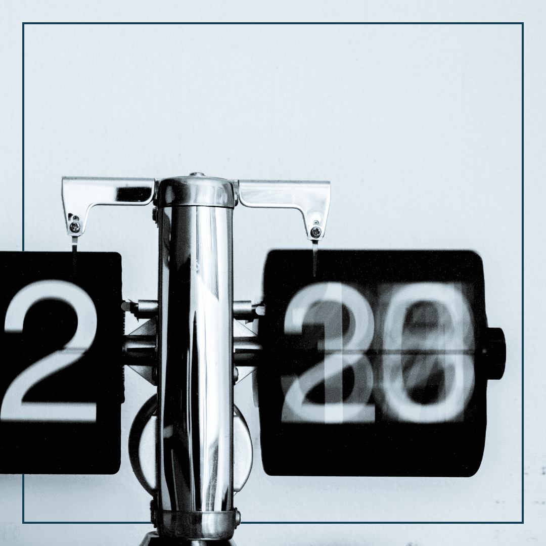 Eine analoge Uhr mit Klappzahlen vor einem weißen Hingergrund