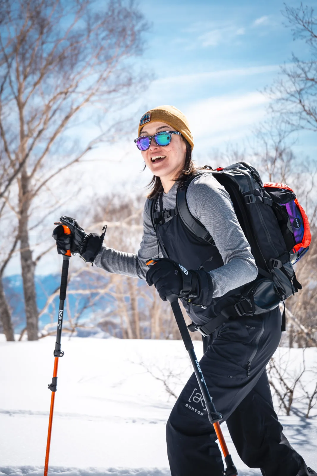 Splitboarder touring uphill on a sunny day in Myoko