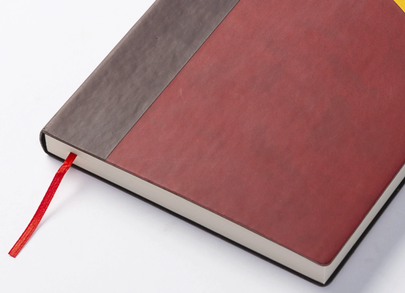 Close-up of notebook spine and red ribbon bookmark.