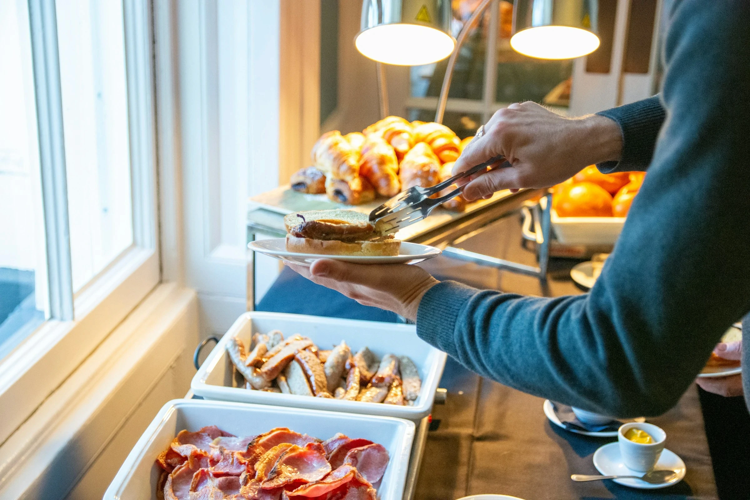 Guest putting something from the buffet on a plate