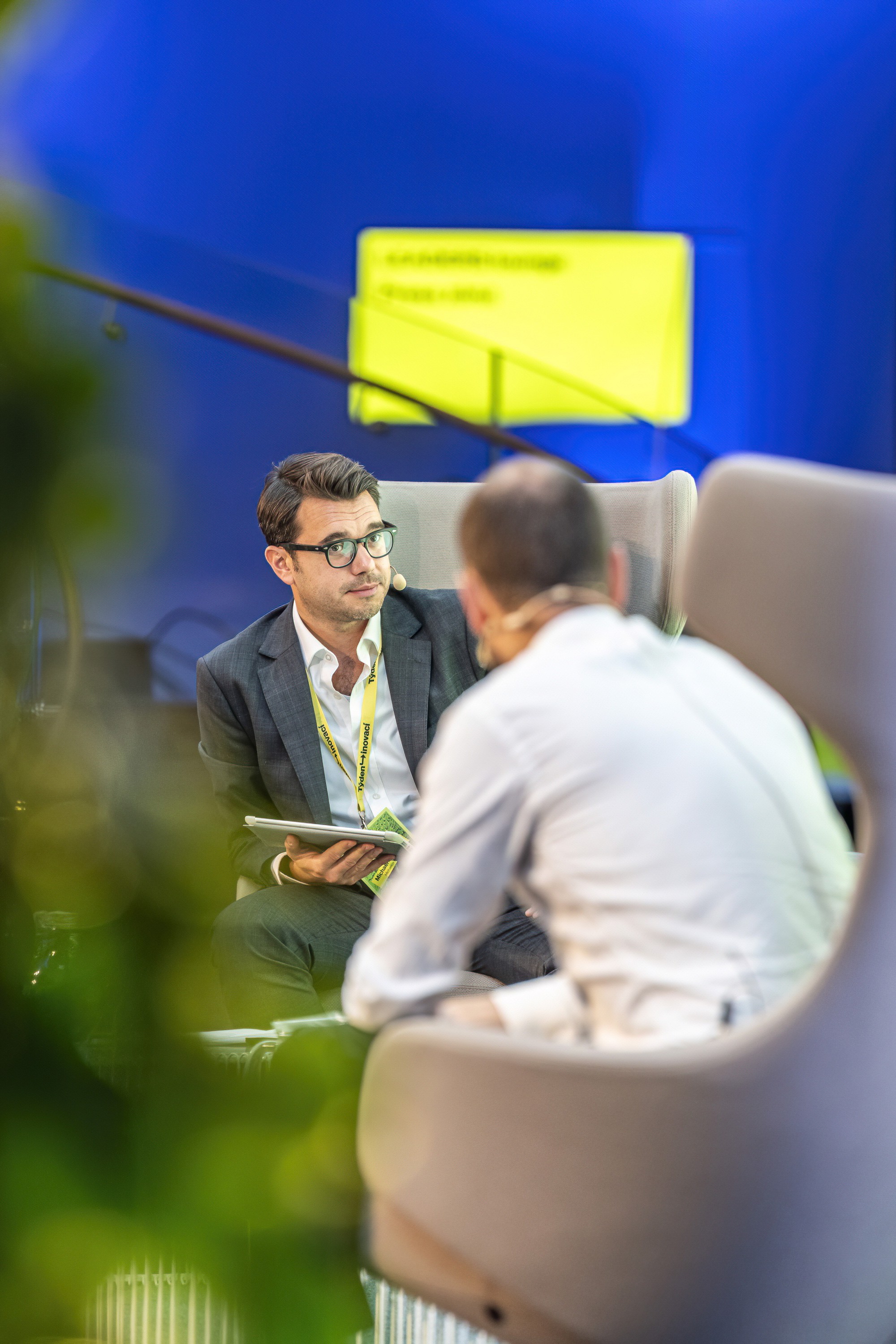One-on-one conversation between speakers during a corporate conference session.