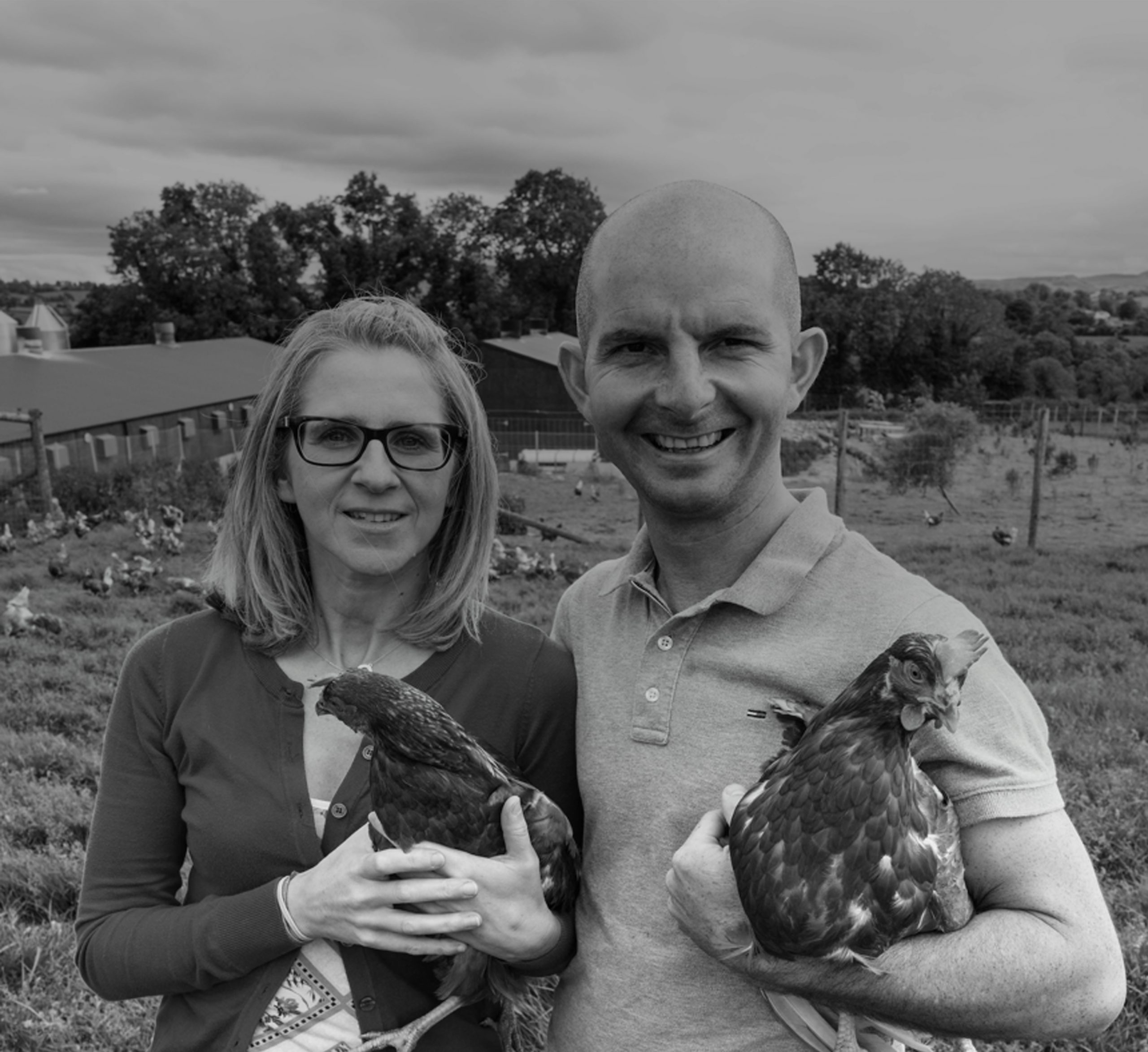 Owners of Chapel Lane Eggs laughing in their field with their chicken in their arms while supplying their goods to As One Restaurant Dubliln