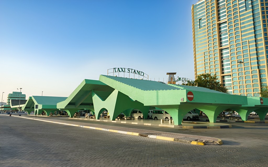 A large green building in Al Seef, showcasing modern architecture against a clear blue sky.