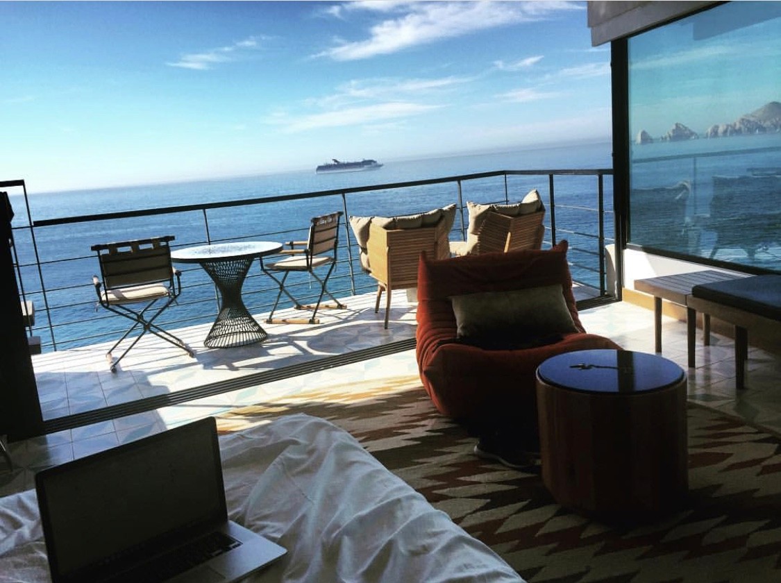 A cozy room with modern furniture and a stunning ocean view through large windows.