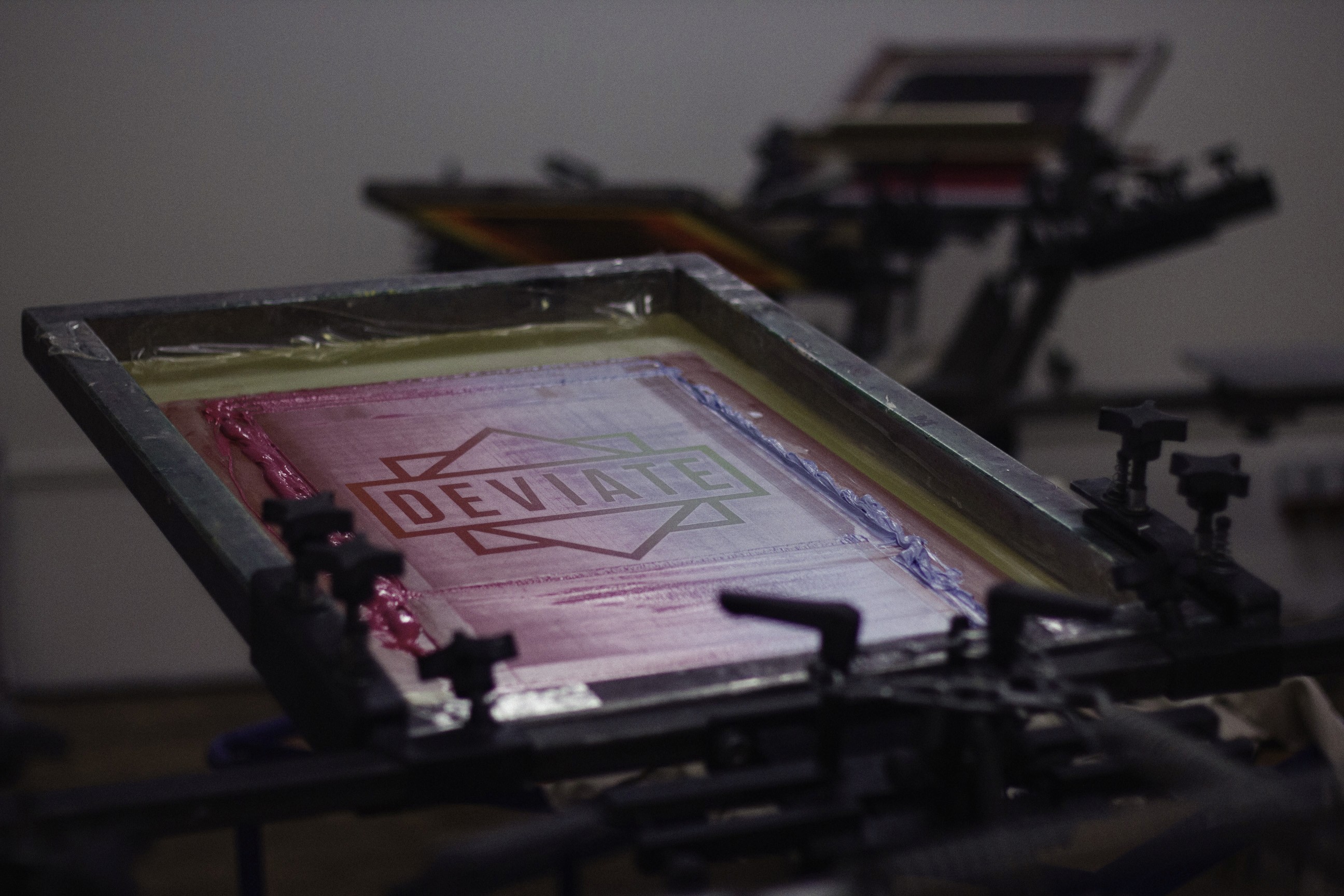 Ein Siebdruckkarussell und eingespannter Siebdruckrahmen mit deviate-Motiv