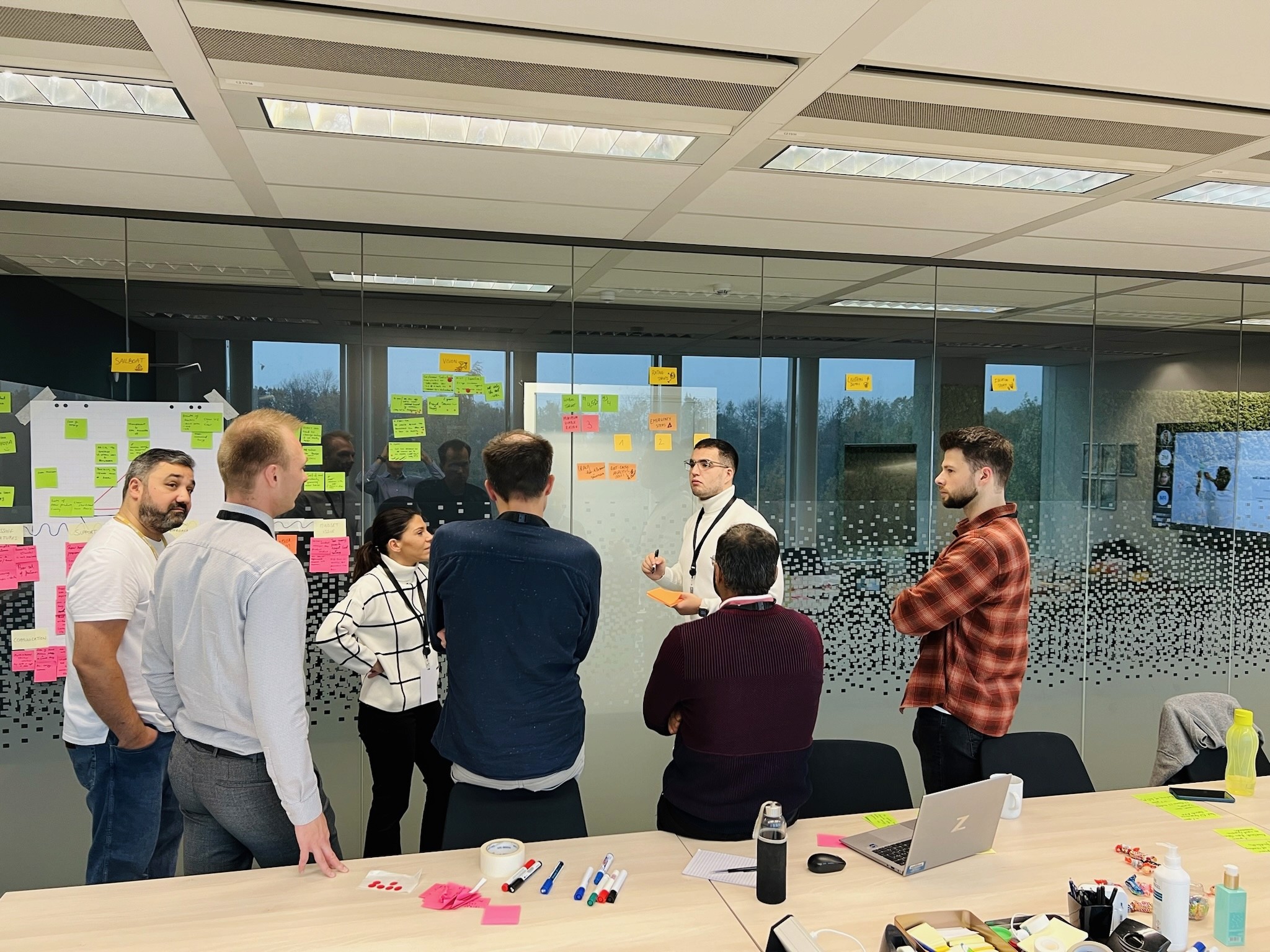 Team retreat session with professionals gathered around a table, engaging in collaborative activities in a bright meeting room