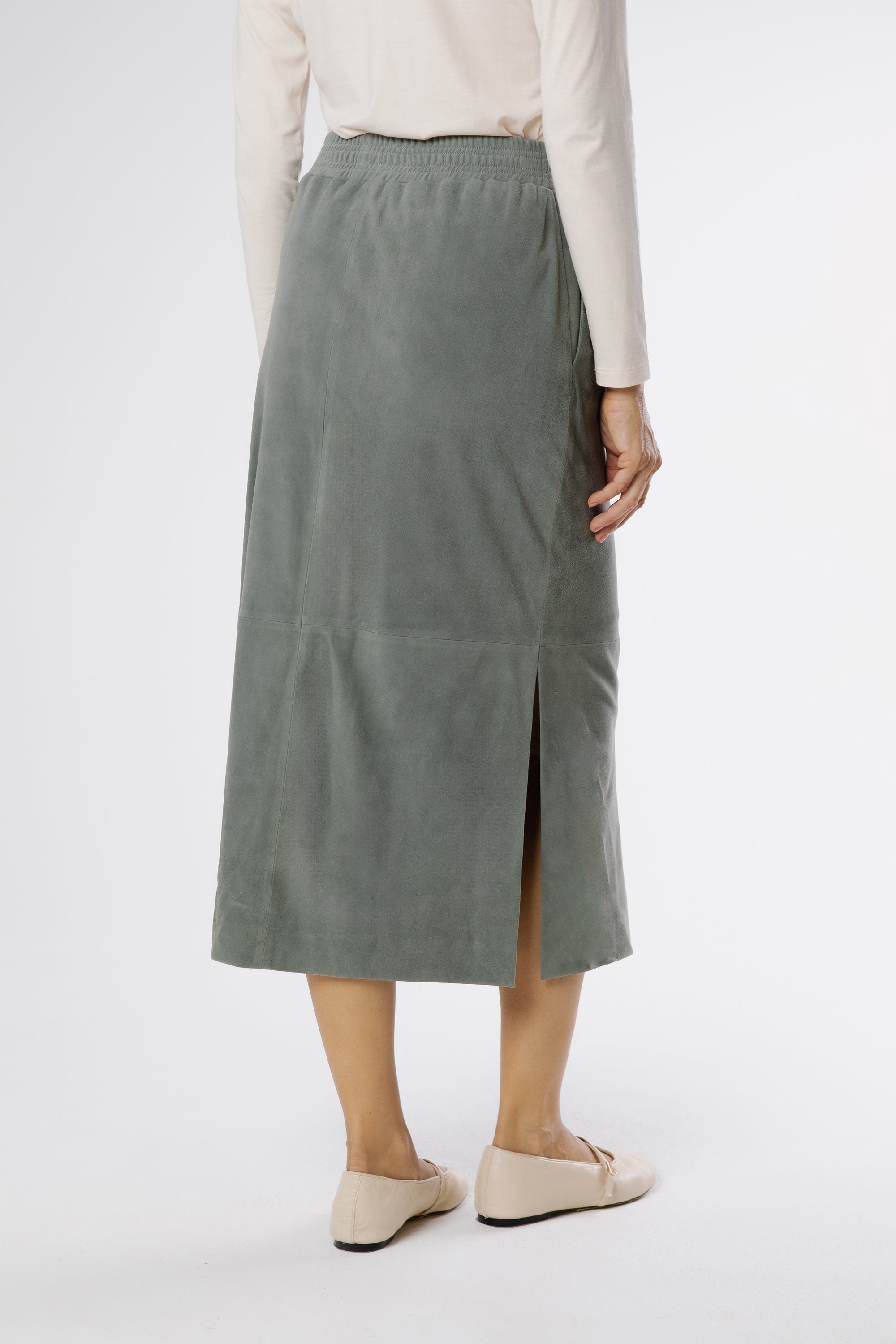 Back view of konbu green suede midi skirt highlighting minimal design and comfortable elastic waist