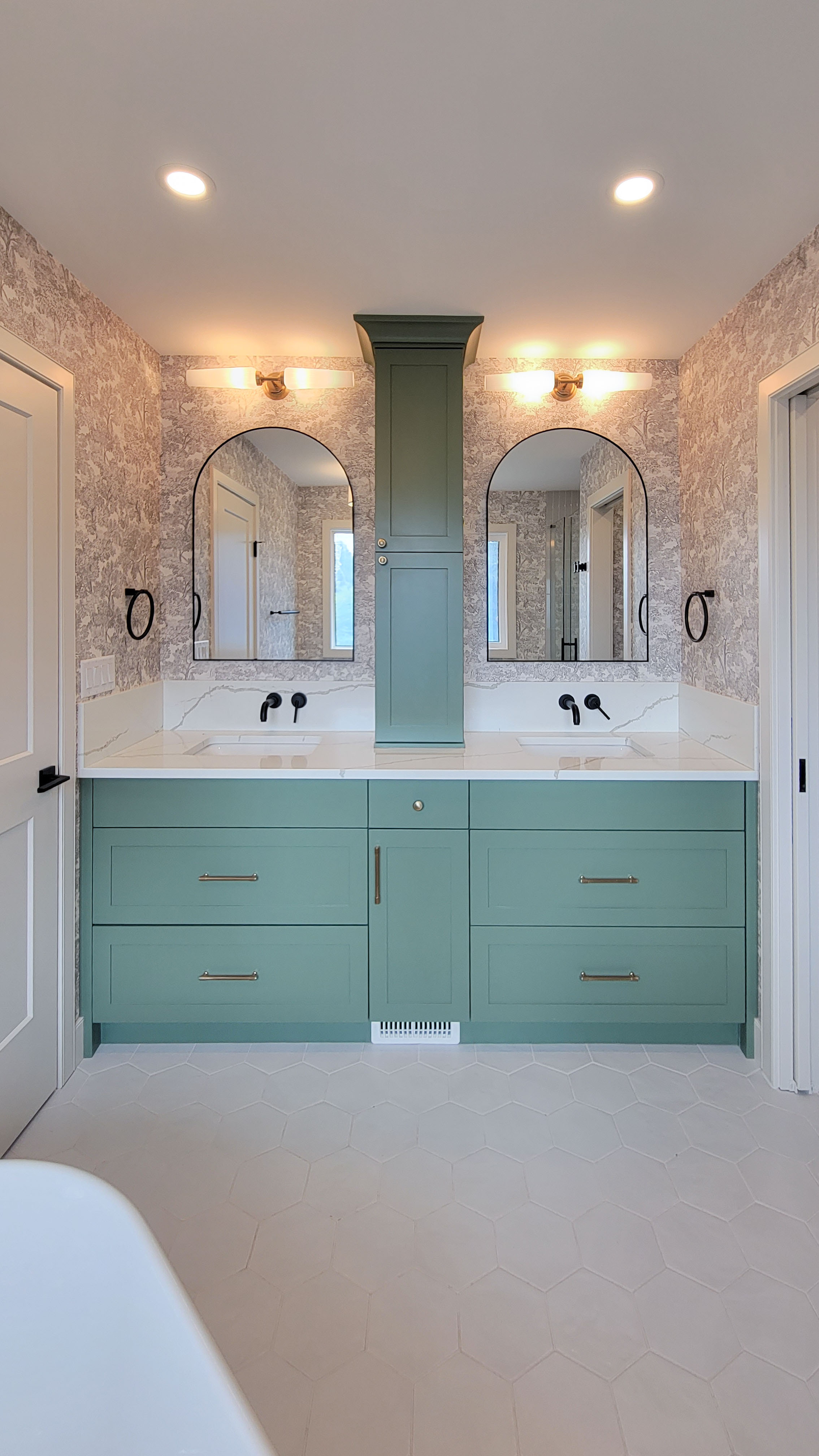 Image of Luxurious primary ensuite bathroom with green cabinets, double vanity, and marble countertop by KHD Homes.