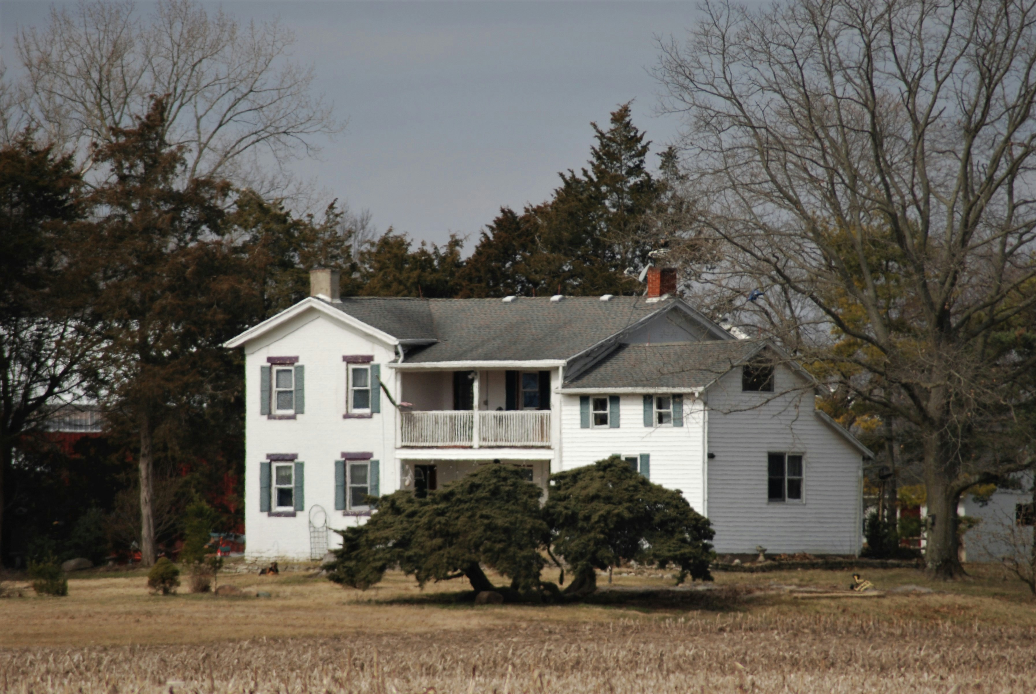 a large white house sitting in the middle of a field