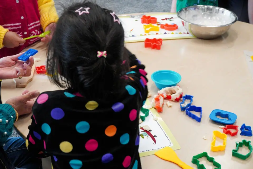 A child making cookies with cookie cutters.