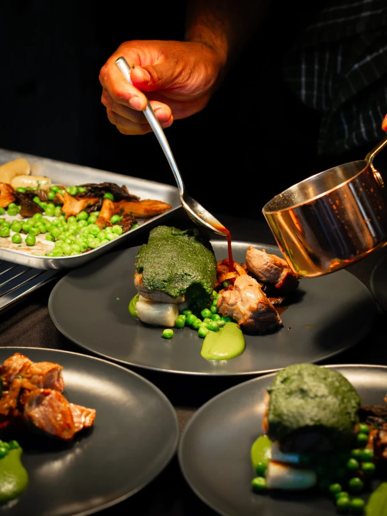 Lamb sauce spooned from a copper pan over herb crusted Herdwick lamb