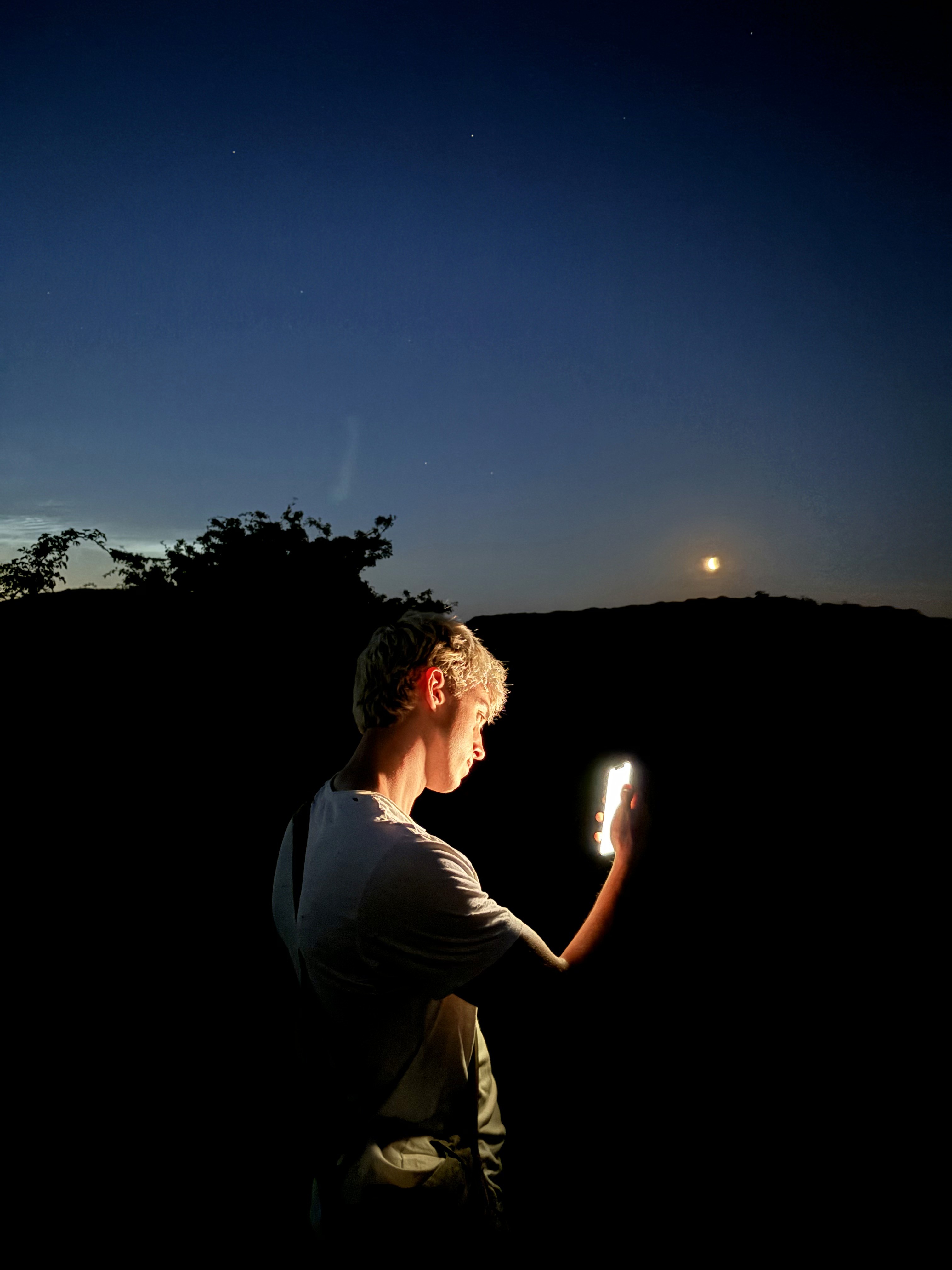 Person, holding a white rose behind his back with one arm on a light blue background