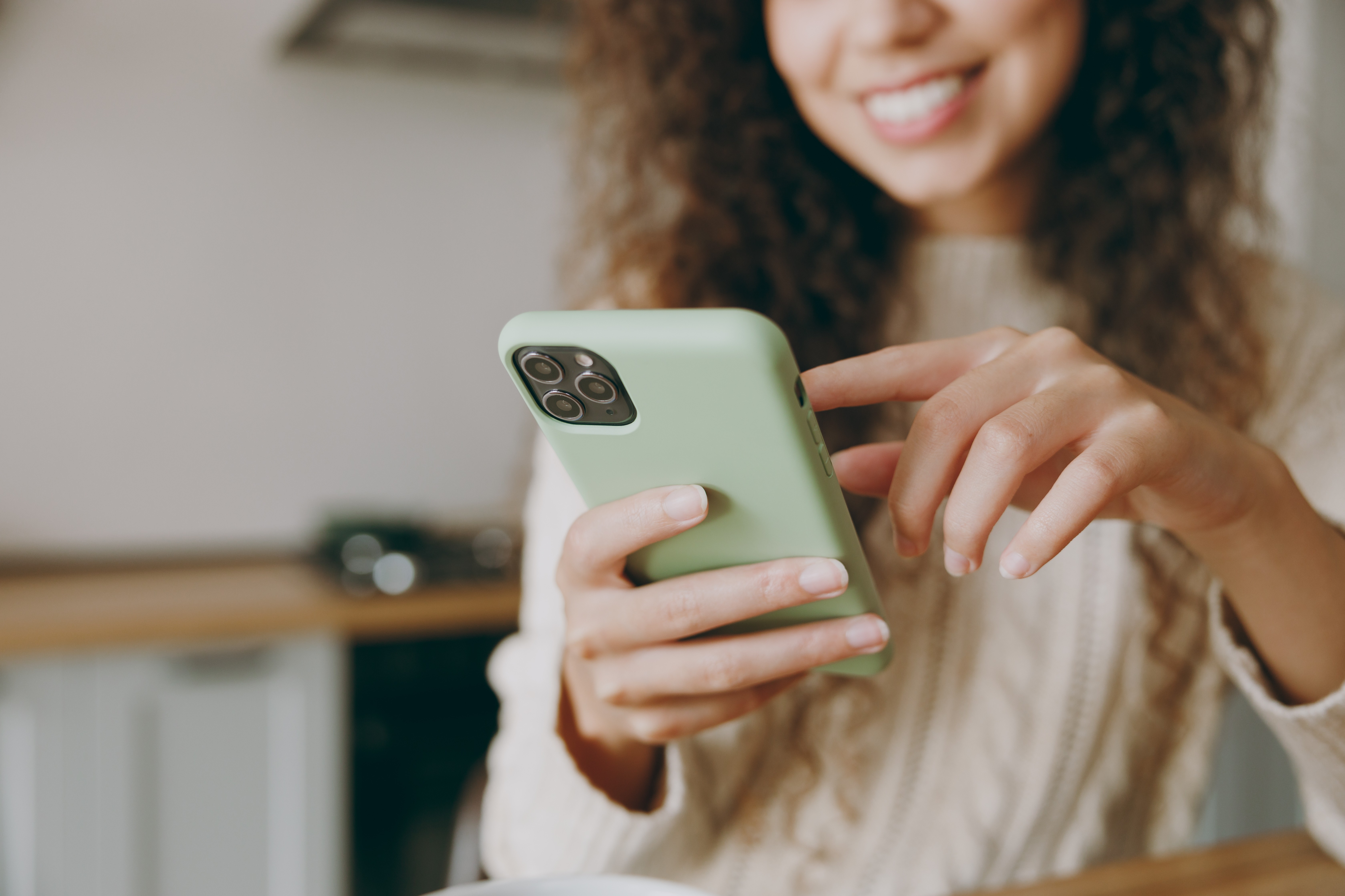 Smiling woman using the Kruidvat app on her smartphone