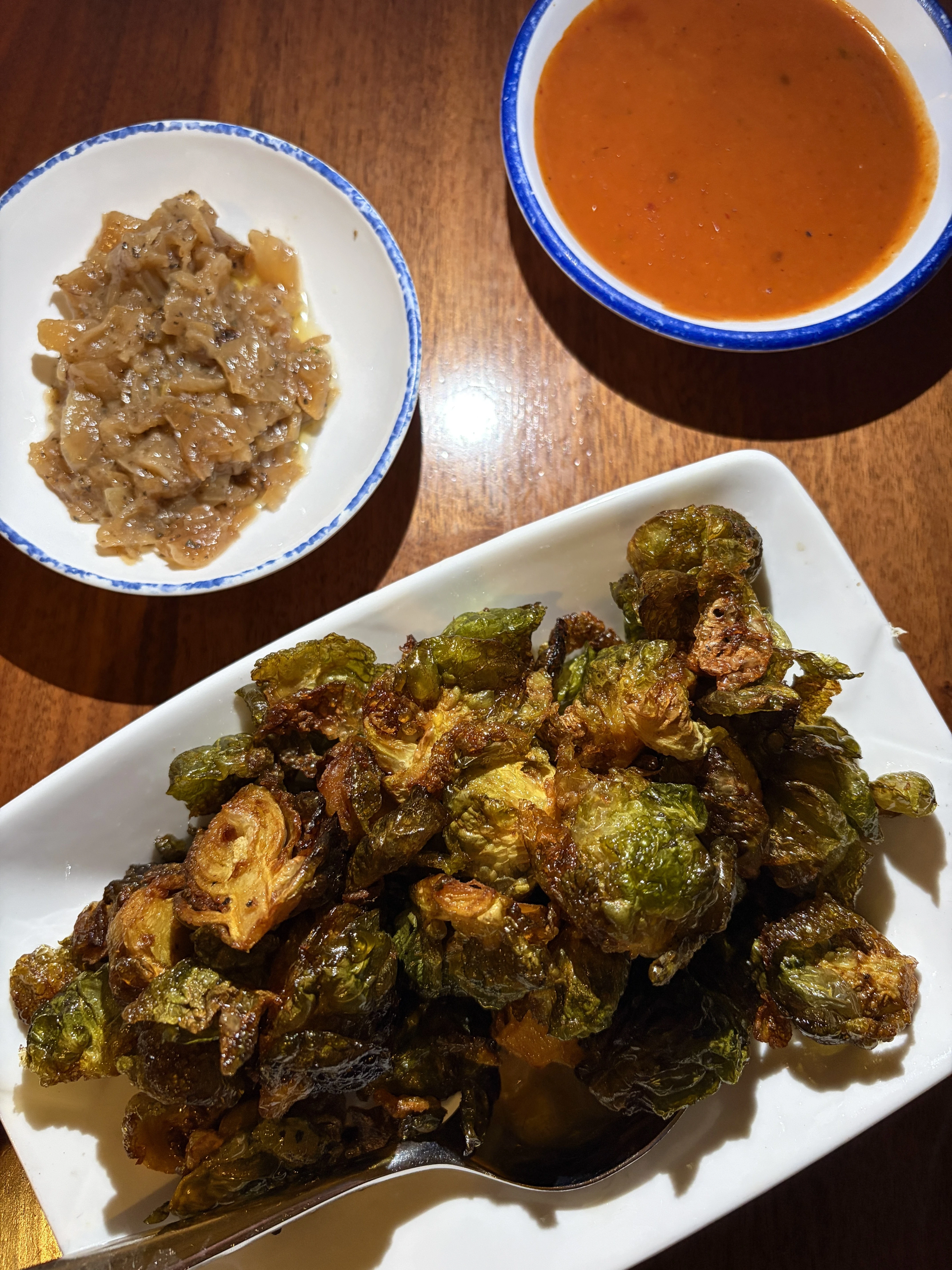 unconventional diner appetizer of brussel sprouts with carmelized onions and a side of tikka masala
