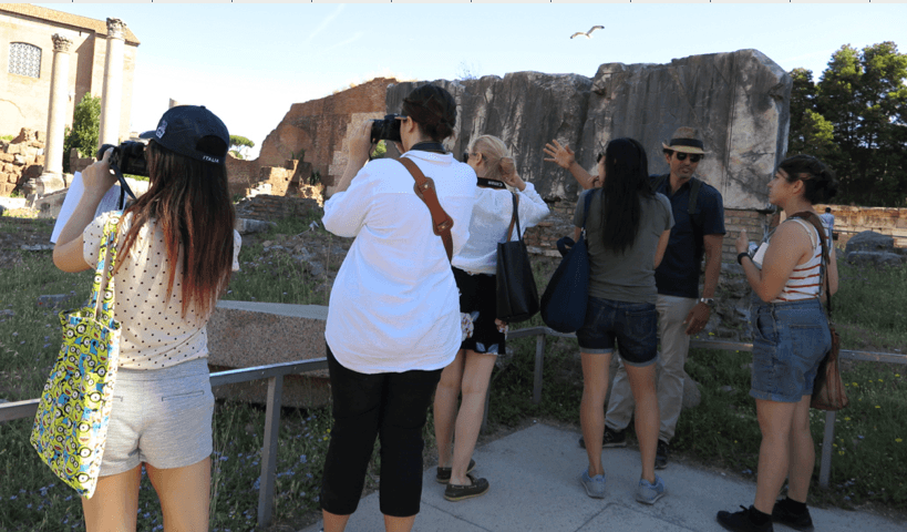 people taking photographs of ruins in rome