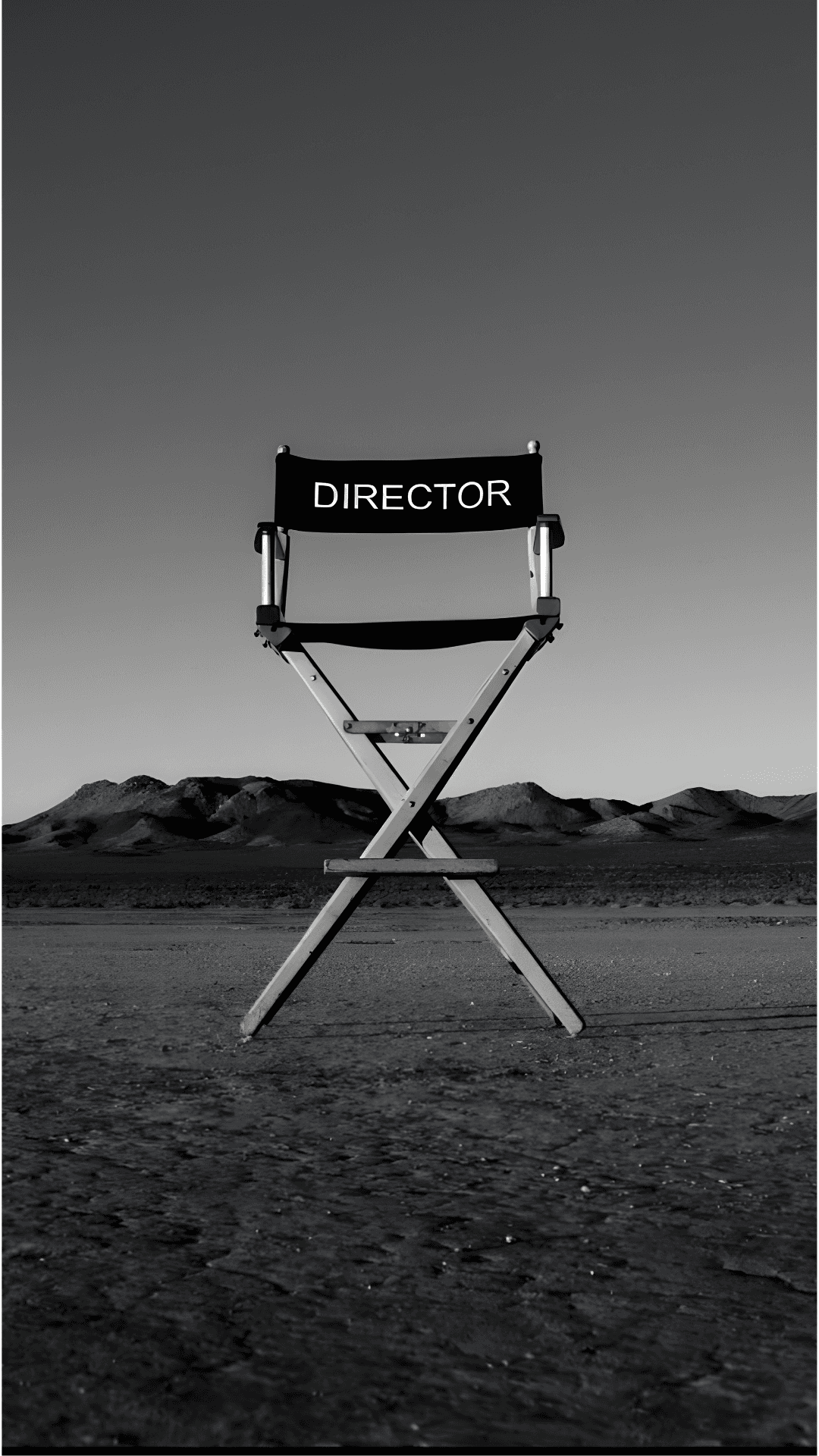 Black and white photo of a director's chair in a desert landscape with the word Director written on it