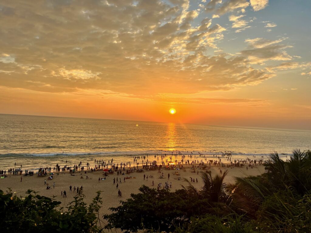 Sunset in Varkala. Captured from the cliff. Coconut palms and people are seen in the picture. 