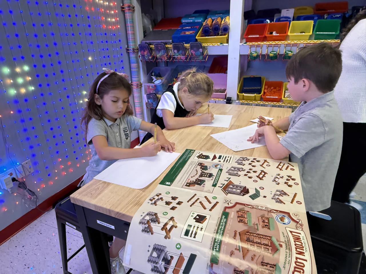 Young students drawing together at a classroom table
